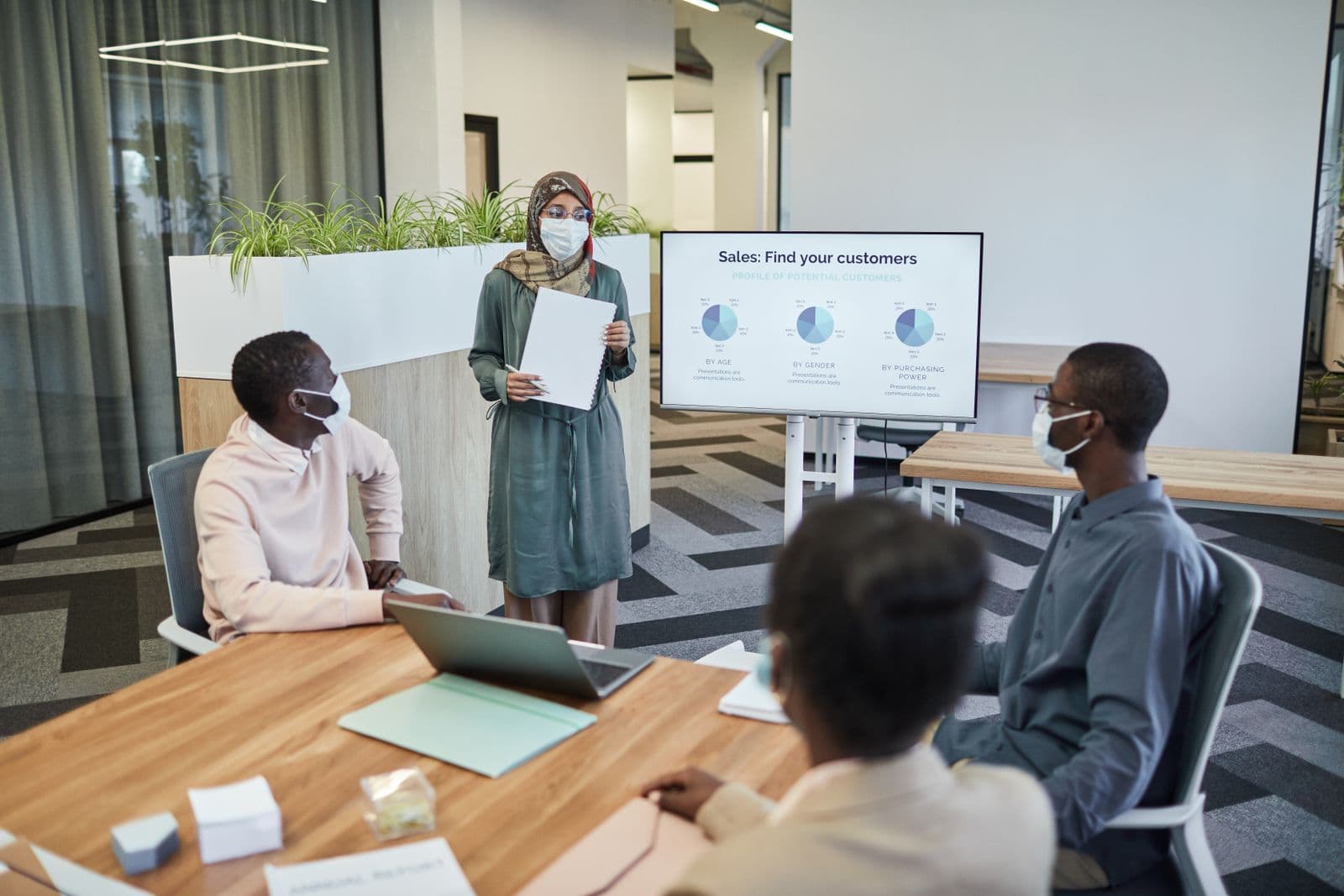 A presenter walking a small group through growth charts on a whiteboard