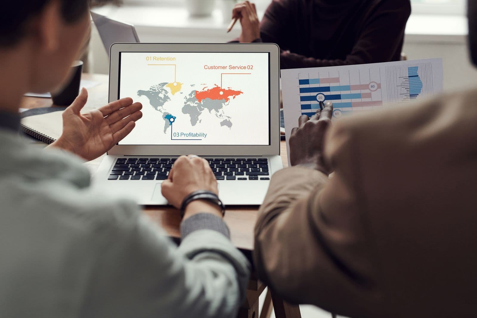 A small team reviewing account data together on a laptop